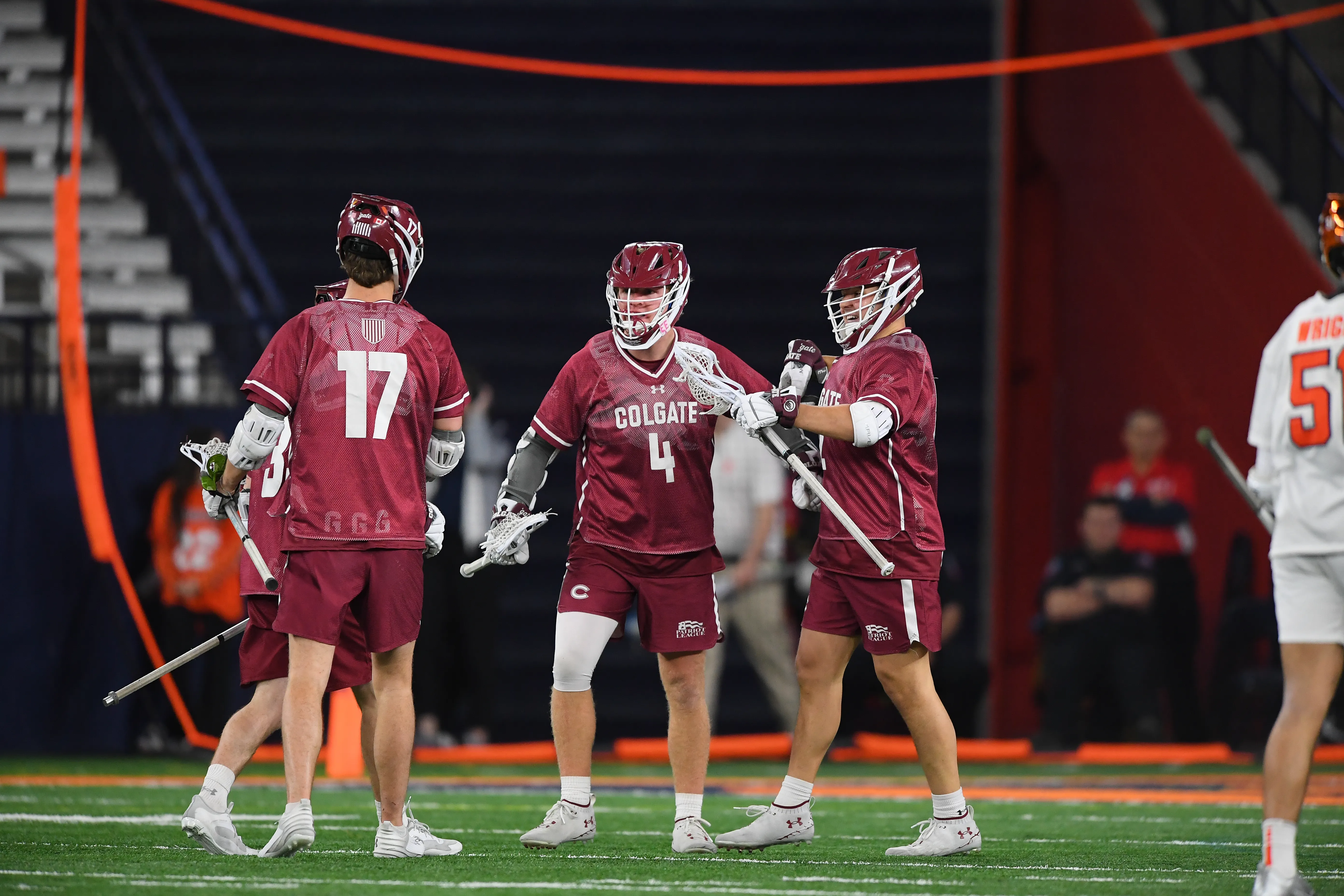 Colgate's Rory Connor (4) celebrates a goal with teammates at the JMA Wireless Dome during a game against Syracuse.