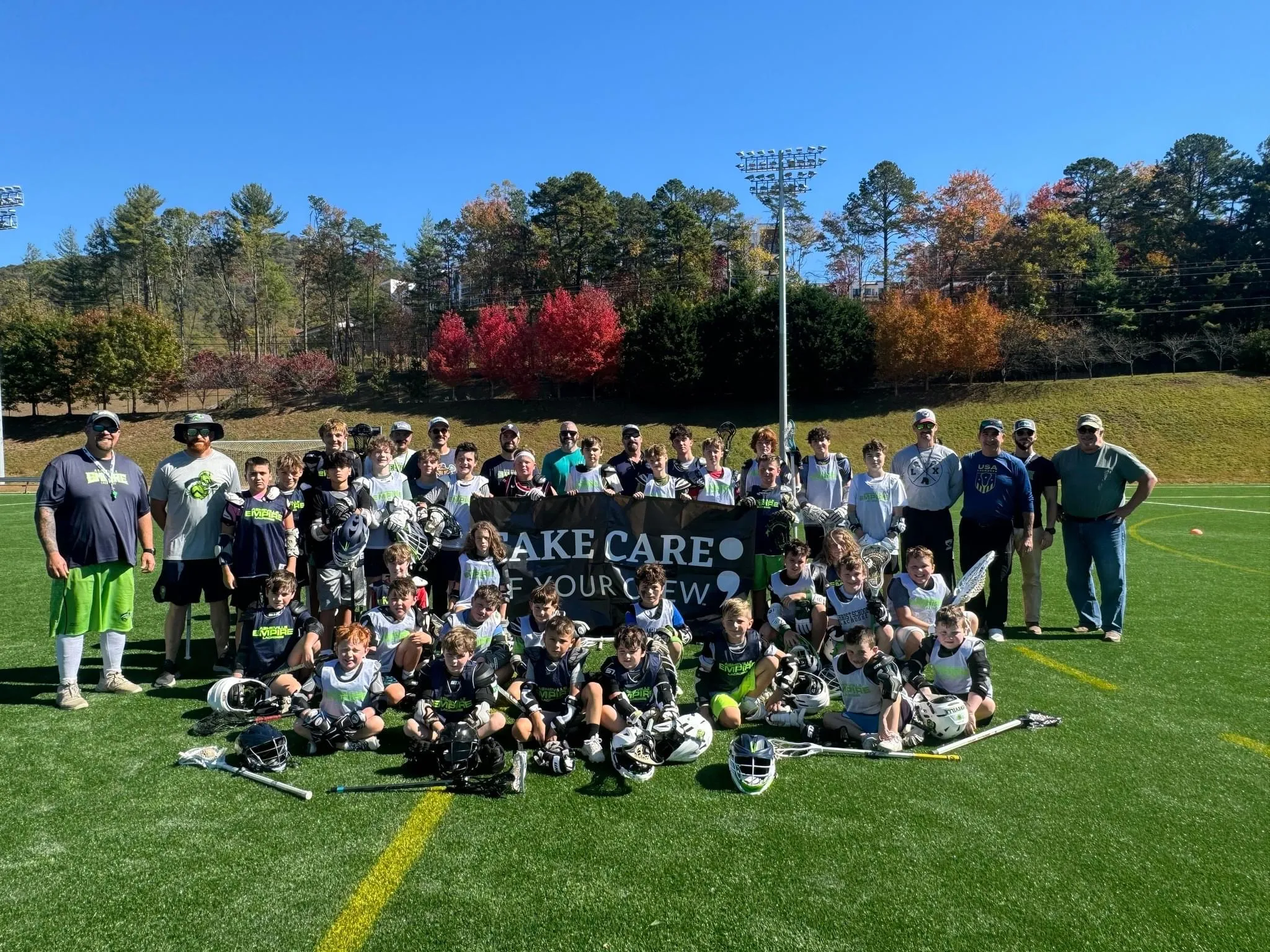 Asheville Empire Lacrosse with sign that reads, "Take care of your crew."