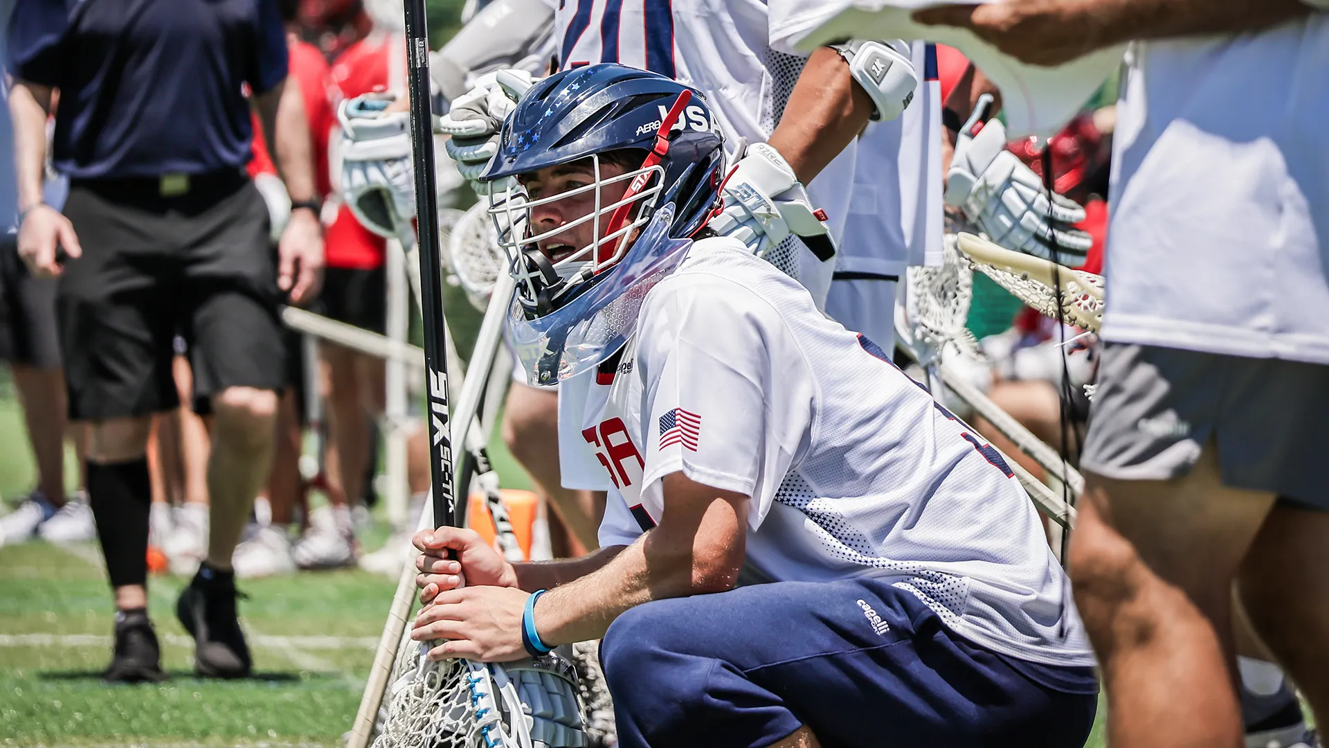 Anderson Moore squatting on the USA sideline during the world championship