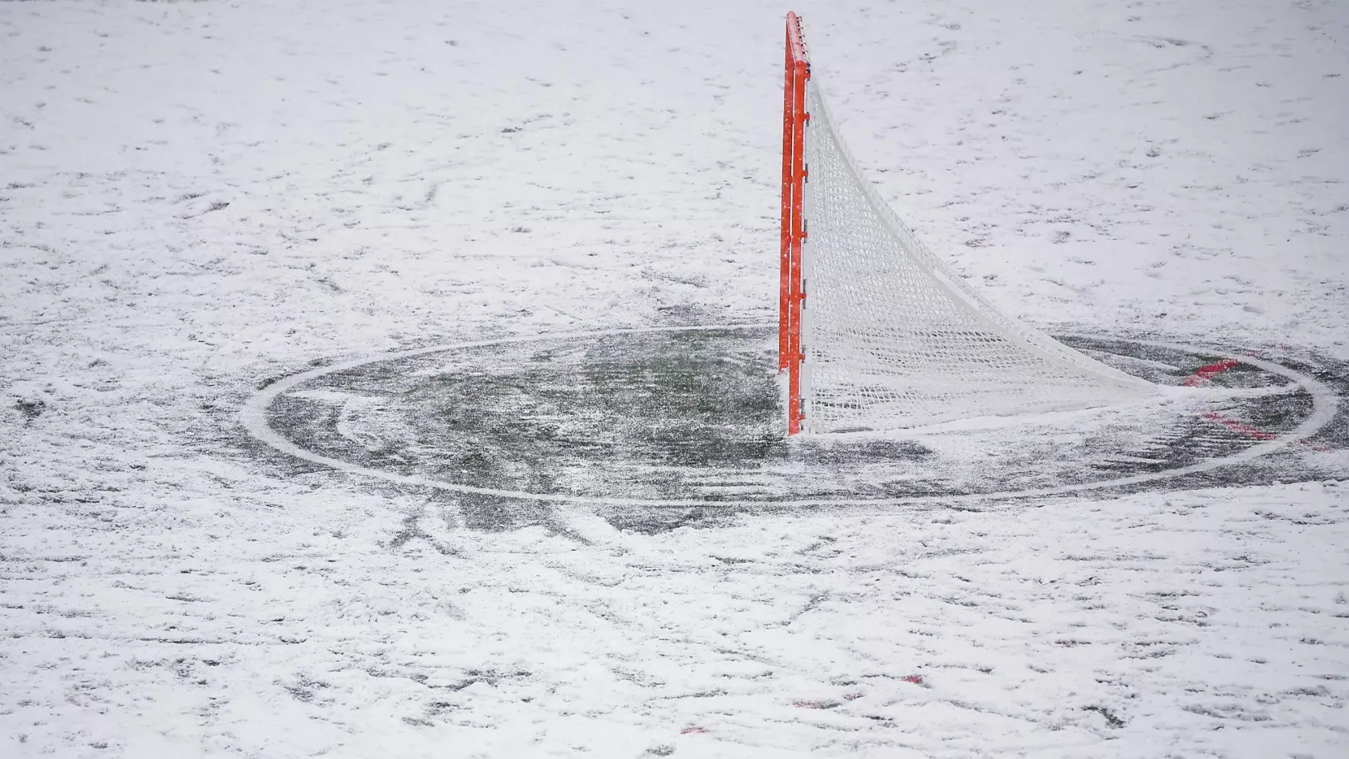 A lacrosse goal with snow surrounding it