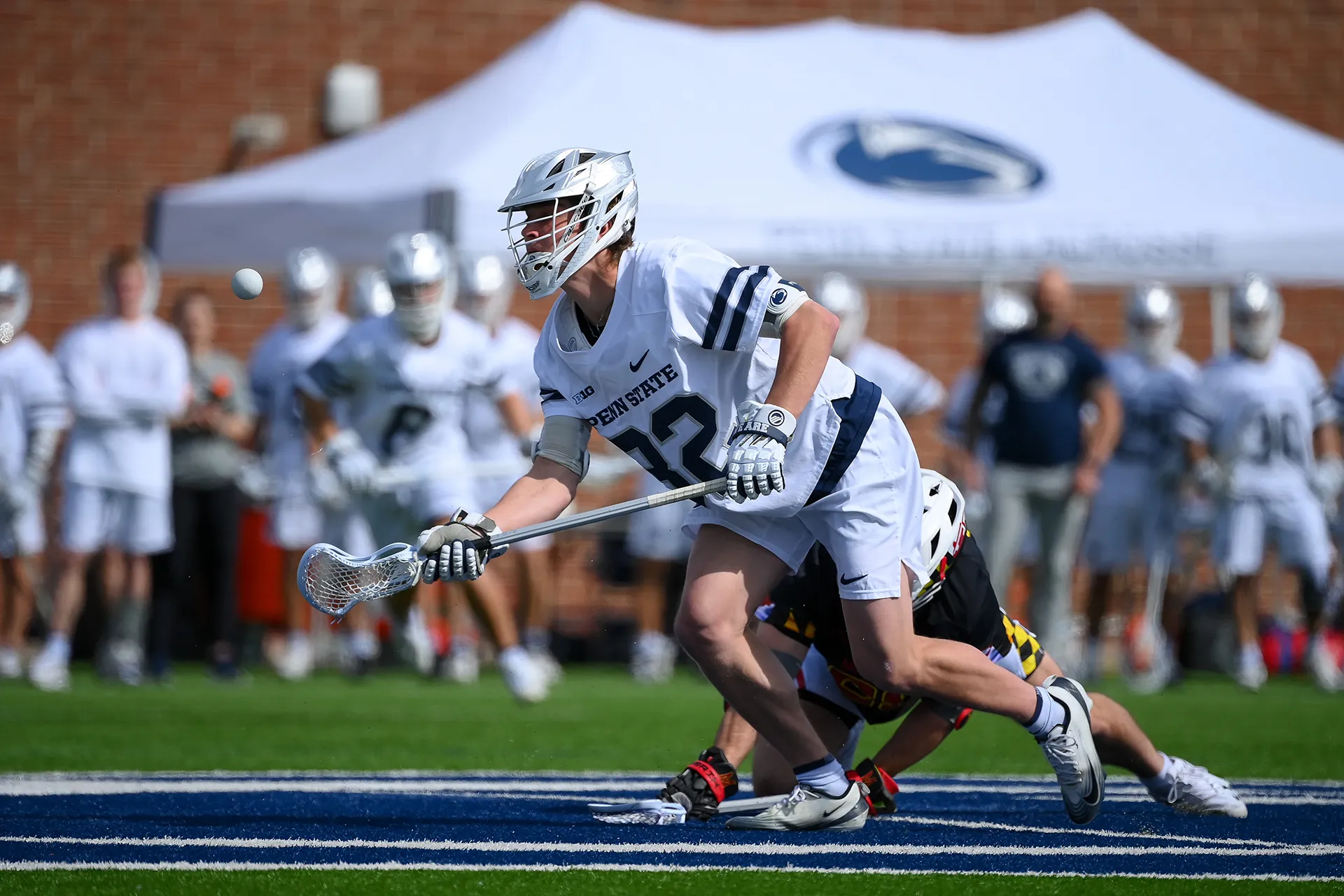 Penn State faceoff specialist Reid Gills pops the ball forward