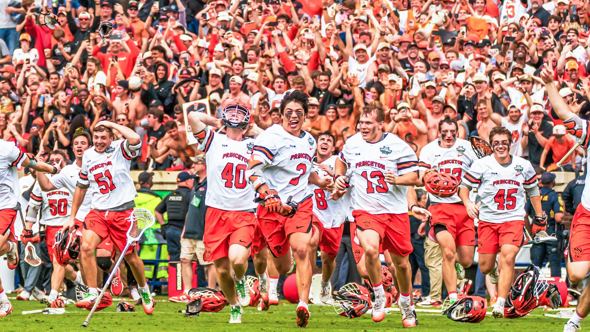 Cody Lam (3) leads a cavalry of Princeton lacrosse players onto the field at Scott Stadium to celebrate after the final buzzer.