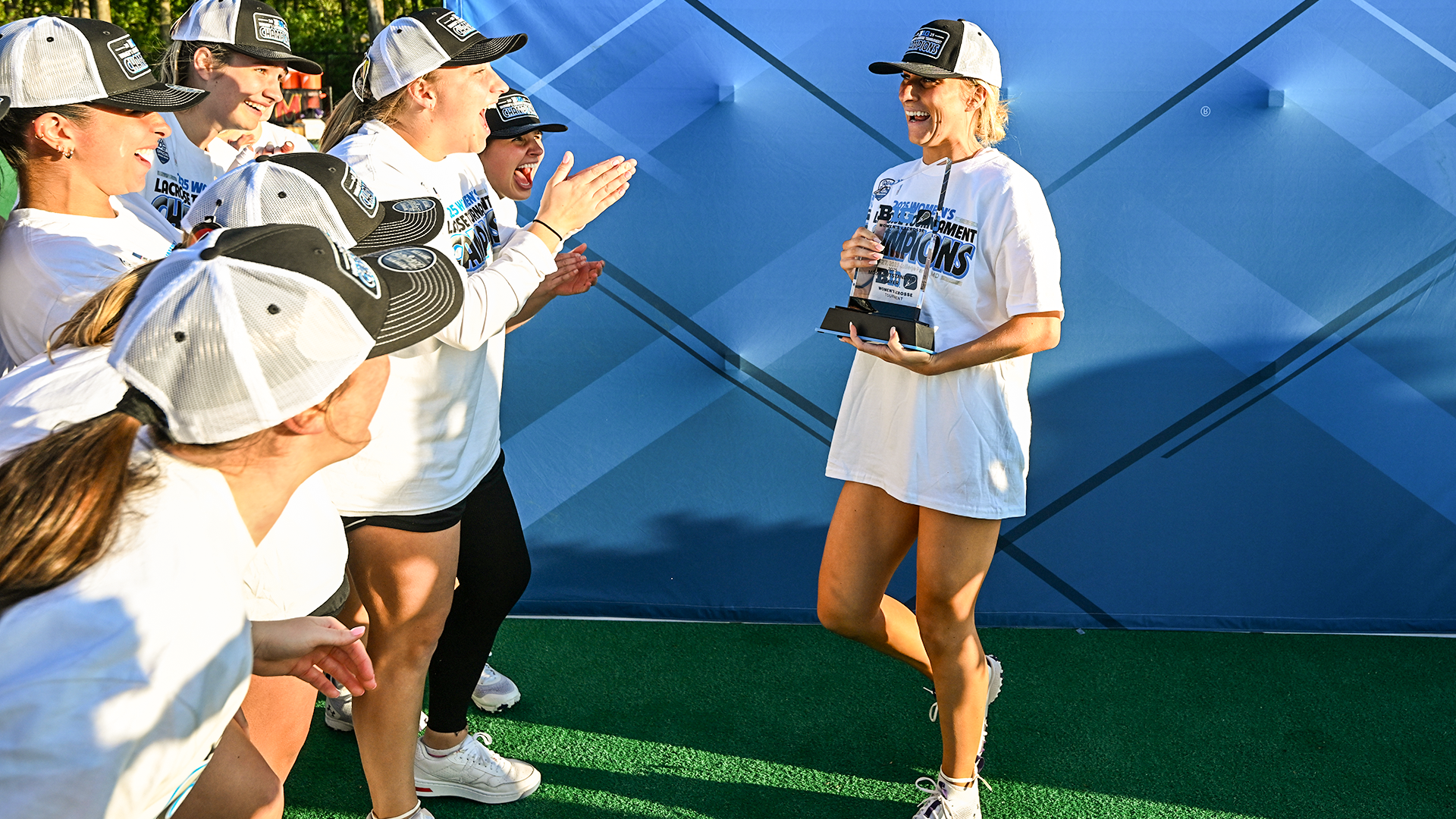 Jane Hansen accepts the Big Ten Women's Lacrosse Tournament Most Outstanding Player trophy and congratulations from her Northwestern teammates