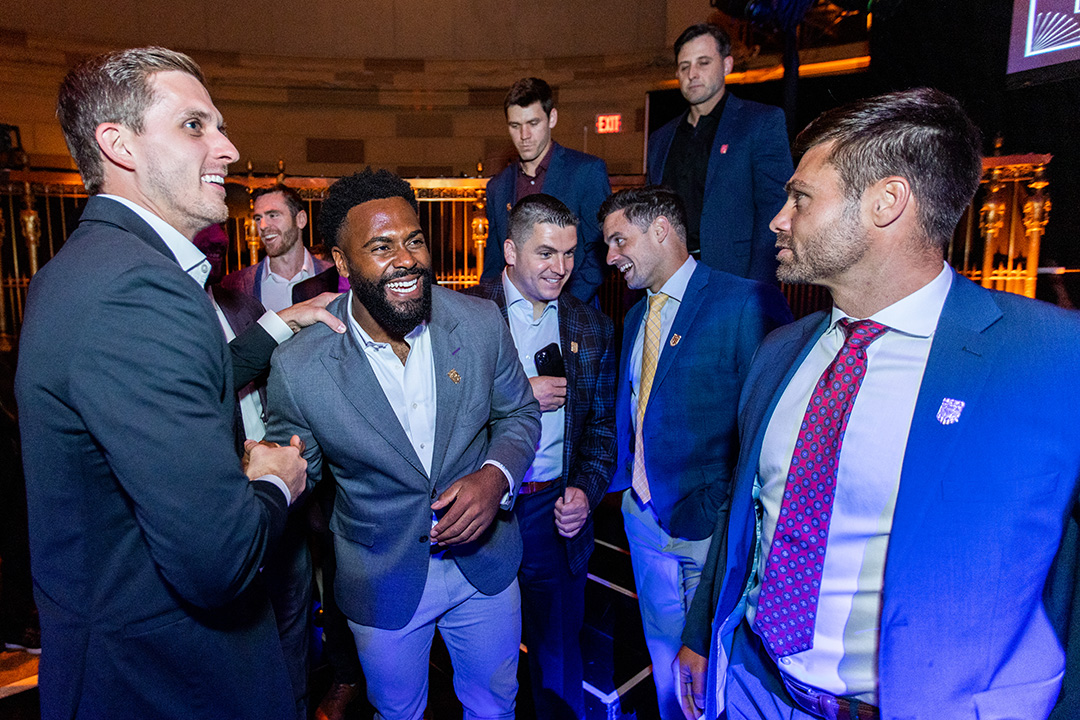 Trevor Baptiste smiles as he's surrounded by other members of the 2023 U.S. men's lacrosse team
