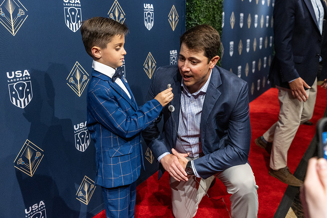 A young fan interviews an attendee at the USA Lacrosse Foundation Gala