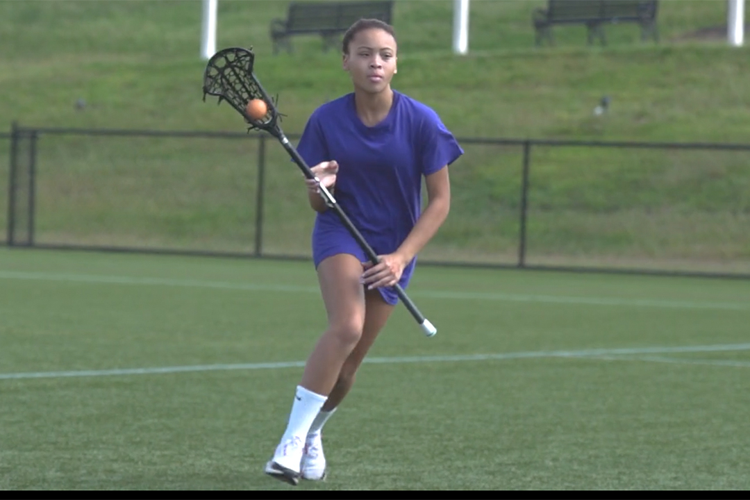picture of young girl cradling a lacrosse ball in her stick