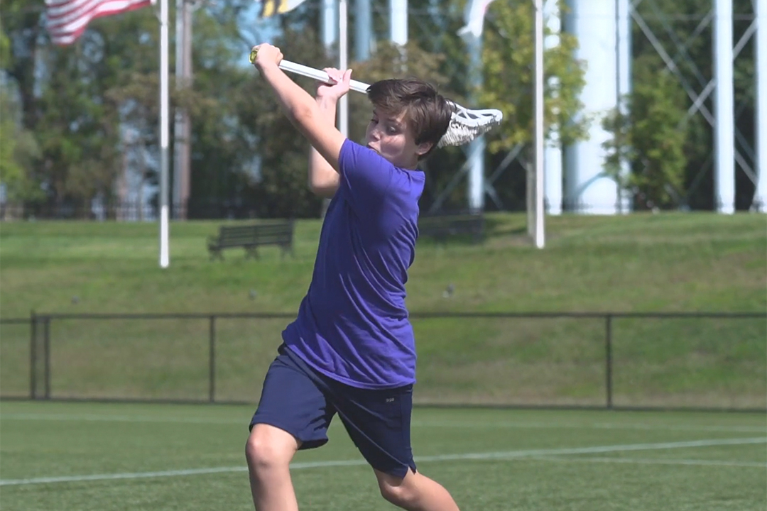 picture of a boy shooting a lacrosse ball