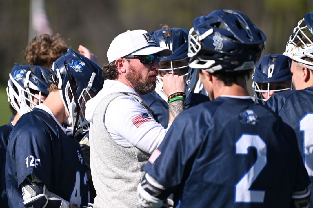 Huddle with a coach and boys' high school lacrosse players