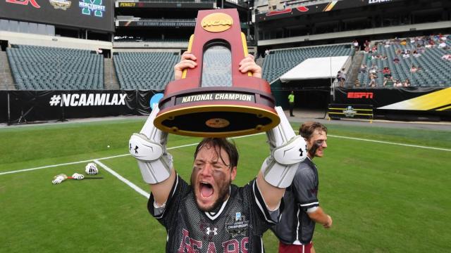 LRU men's lacrosse with trophy