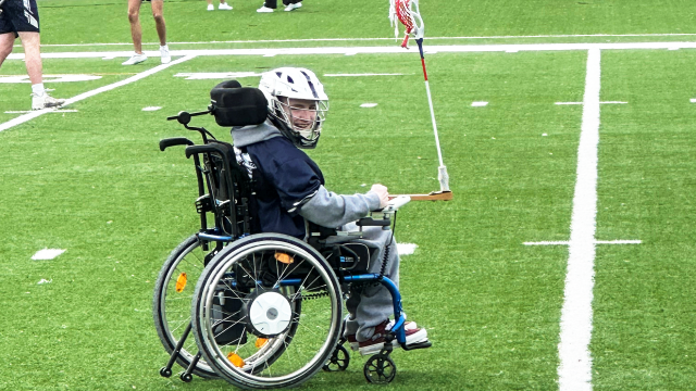 Caleb Krewson of Saints Peter & Paul on the field with his favorite wheelchair accessory — a lacrosse stick