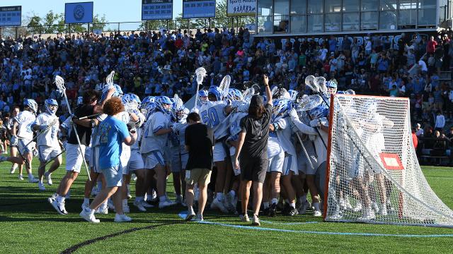 Hopkins men's lacrosse team celebrates in front of goal after clinching Big Ten championship