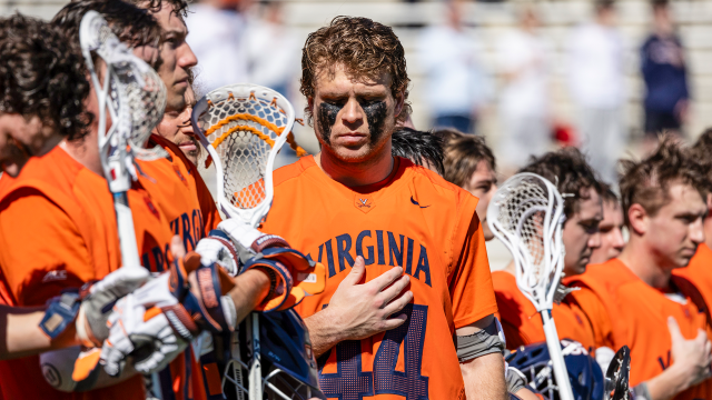 Virginia lacrosse player Ben Wayer holds his hand over his heart during the national anthem before a game against Maryland.