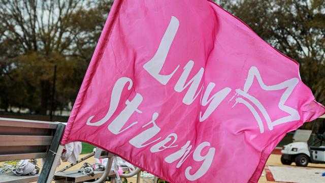 Pink flag with white writing of "Lucy Strong" from the Jacksonville - Navy women's lacrosse game.