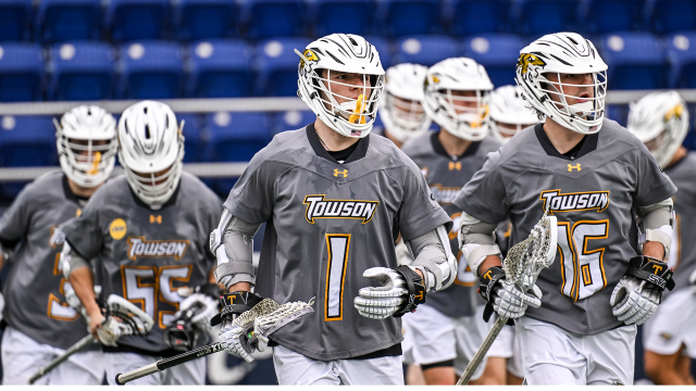 Towson men's lacrosse player Mikey Weisshaar leads the team onto the field at Navy