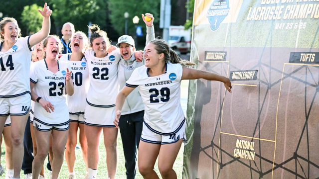 Skylar Lach celebrates after placing Middlebury's placard on the bracket following an OT semifinal win over Colby at Kerr Stadium in Roanoke, Va.