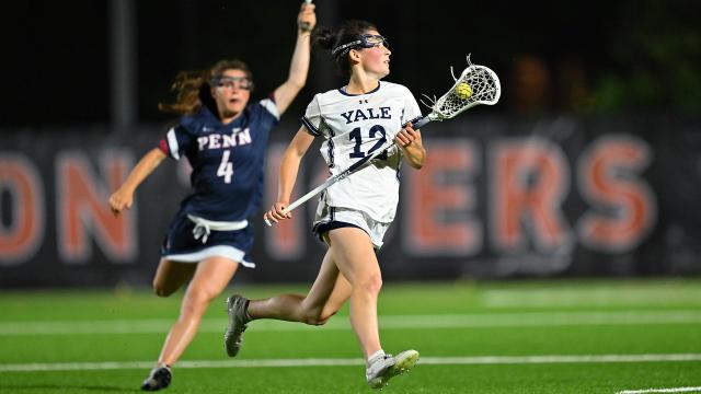 Yale's Taylor Lane cradles the lacrosse ball as a Penn defender gives chase.