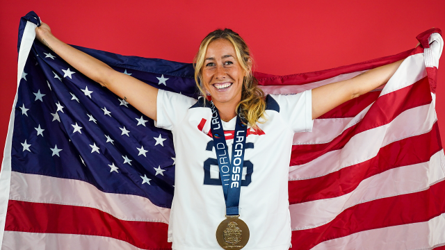 U.S. Women's National Team player Lizzie Colson bearing the American flag on her back and gold medal around her neck during a 2022 portrait shoot at USA Lacrosse headquarters in Sparks, Md.