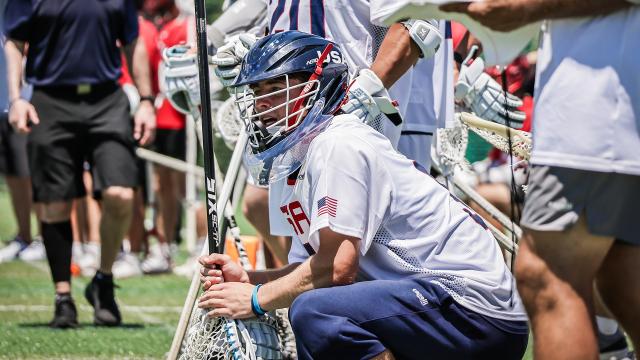 Anderson Moore squatting on the USA sideline during the world championship