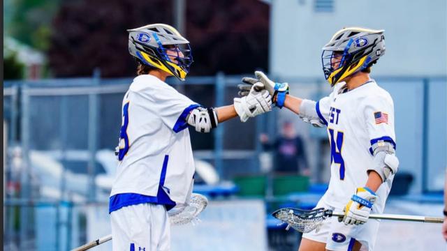 Downington West boys' lacrosse players celebrate a goal