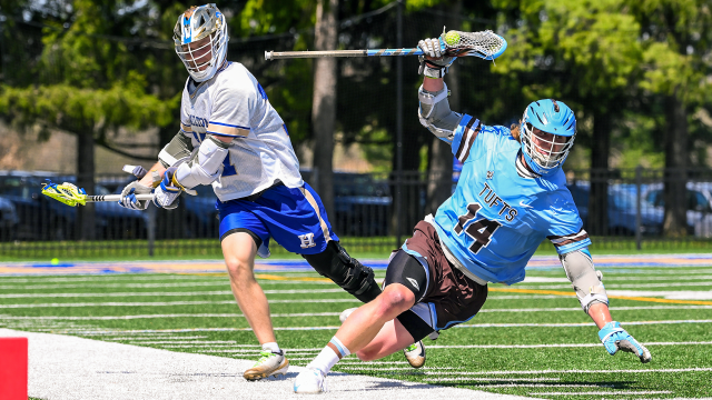 Garrett Kelly of Tufts lacrosse maintains possession of the ball while falling near the sideline during a game against Hamilton.