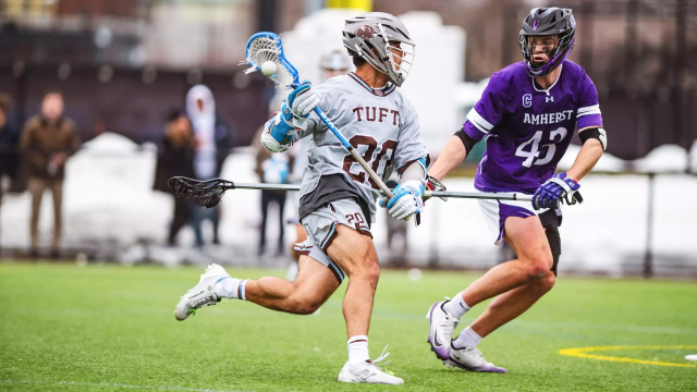 Tufts lacrosse player Jack Regnery attacking against an Amherst defender