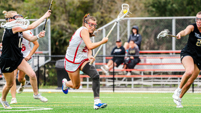 Flagler women's lacrosse player Jessica Wright evades a pair of Anderson defenders