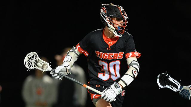 RIT's Ryan Sanders carries the ball during a night lacrosse game