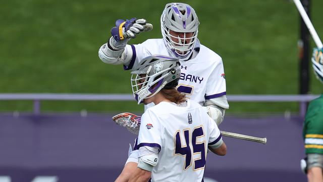 UAlbany men's lacrosse players celebrating during their America East championship game