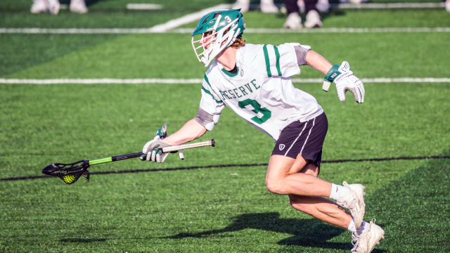 A Western Reserve (Ohio) lacrosse player running with ball up the field and stick extended