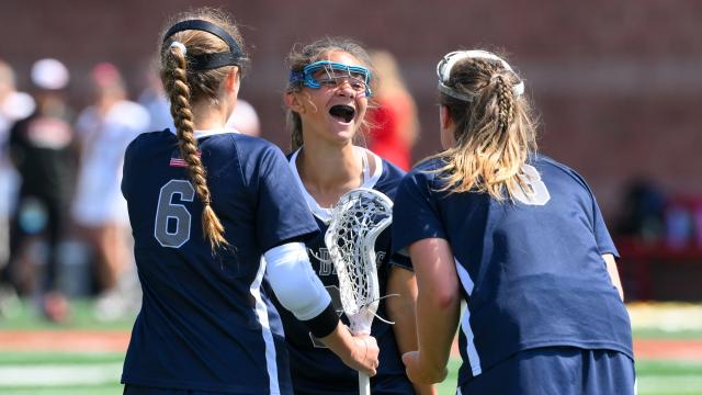 Huntington (N.Y.) girls' lacrosse players huddle to celebrate after scoring a goal in the New York Class A final at Cortland