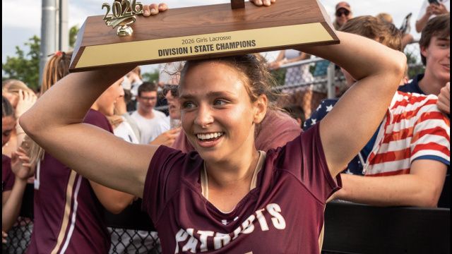 Concord-Carlisle's Sarah Fortier with the Massachusetts state championship trophy raised above her head
