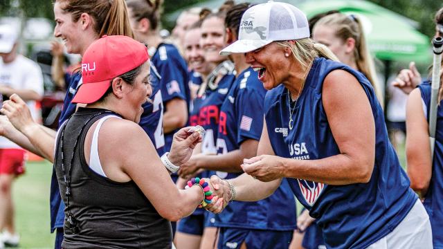 U.S. Women's National Team head coach Acacia Walker-Weinstein exchanges gifts with a coach from Peru at the 2025 Pan-American Women's Lacrosse Championship.