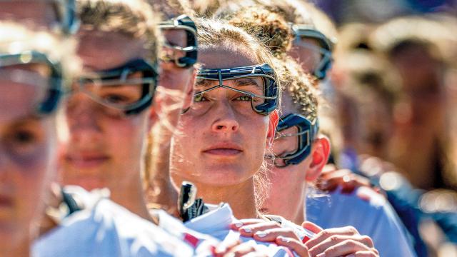 Anna Brandt places her left hand on Sydney Scales' left shoulder and hand over her heart during the playing of the national anthem at the 2025 Pan-American Women's Lacrosse Championship in Florida.