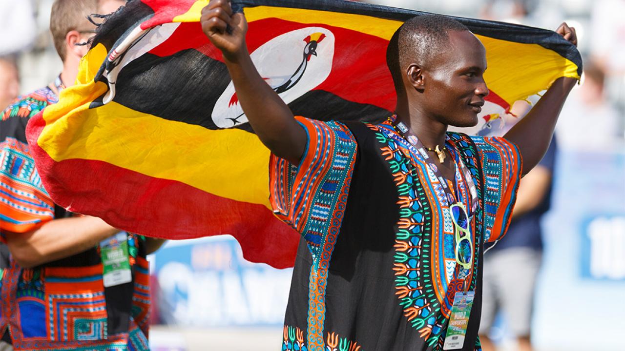 Draped by a Ugandan flag, Jaffari Makanda basks in the adulation during opening ceremonies of the 2014 world lacrosse championship.