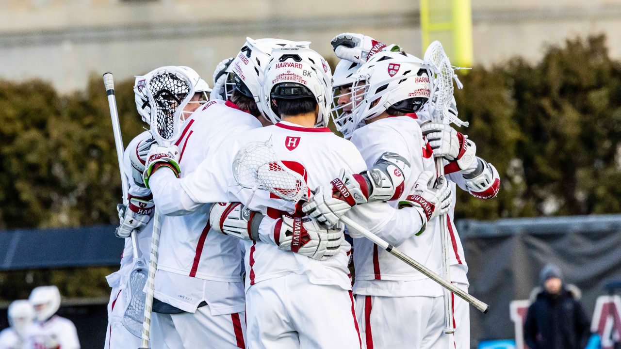 Harvard men's lacrosse huddle after a goal