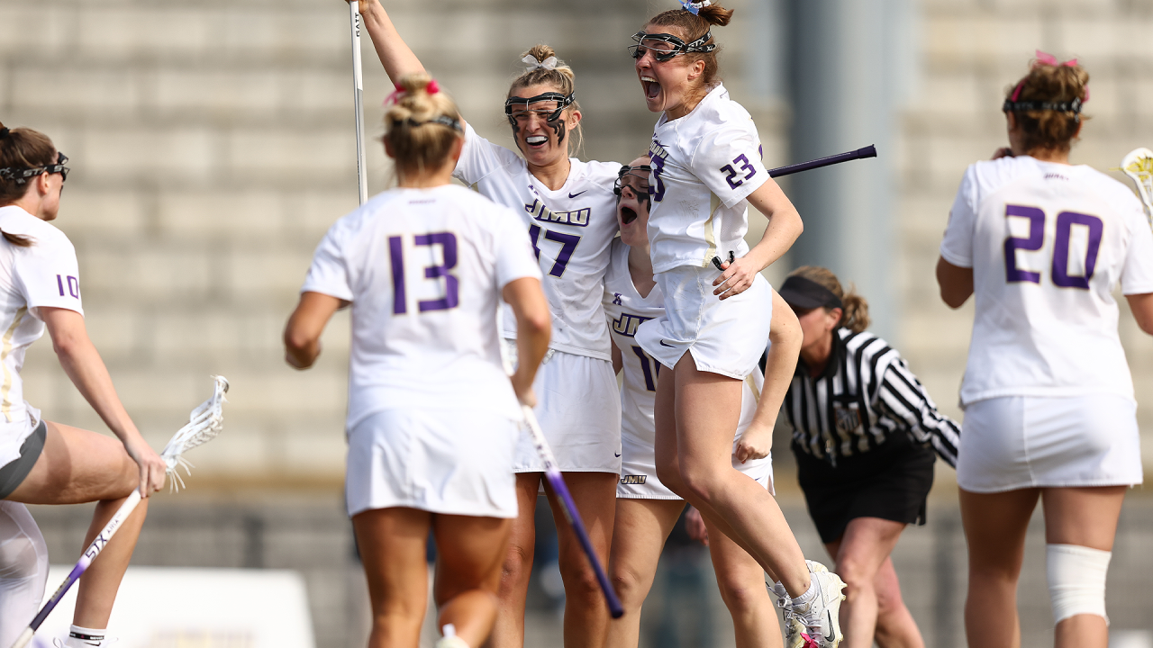 JMU players celebrate Kaitlyn Morgan's OT winner.