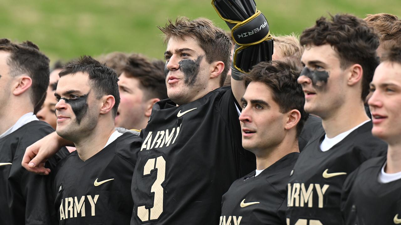 Jackson Eicher is surrounded by his teammates after scoring the game-winning goal against Navy.