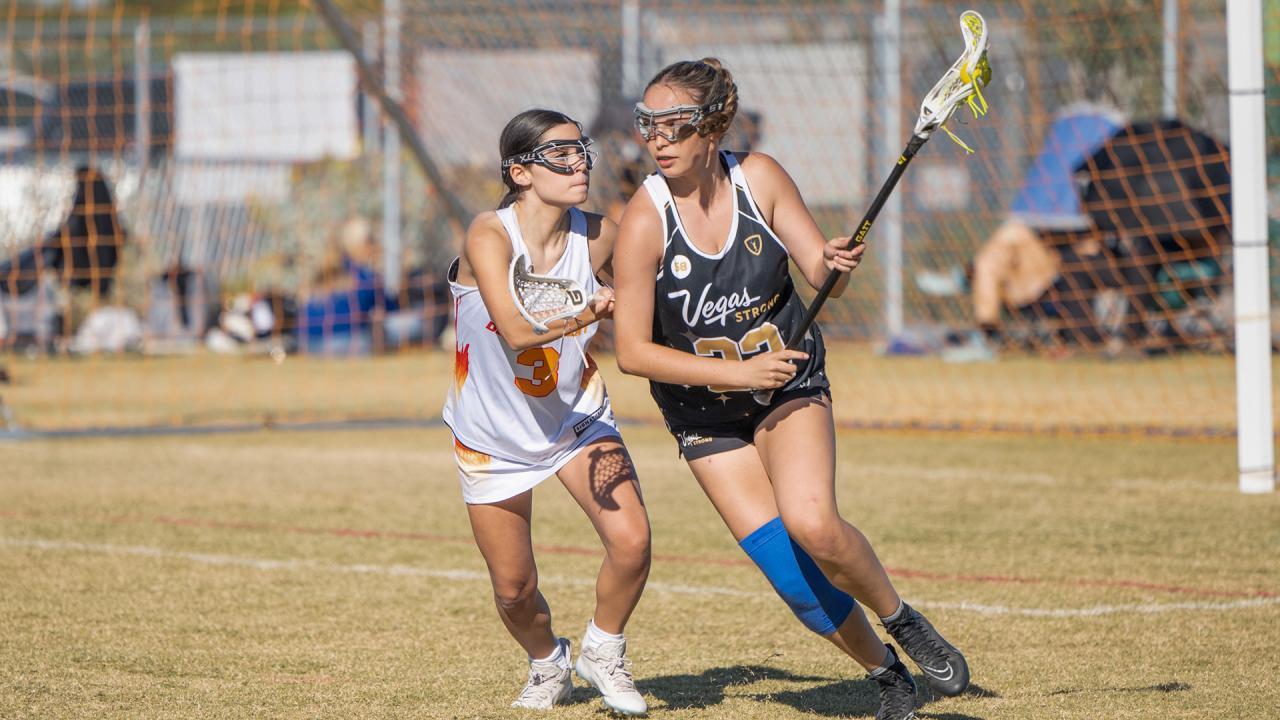 Vegas Strong girls' club lacrosse player runs with the ball. 