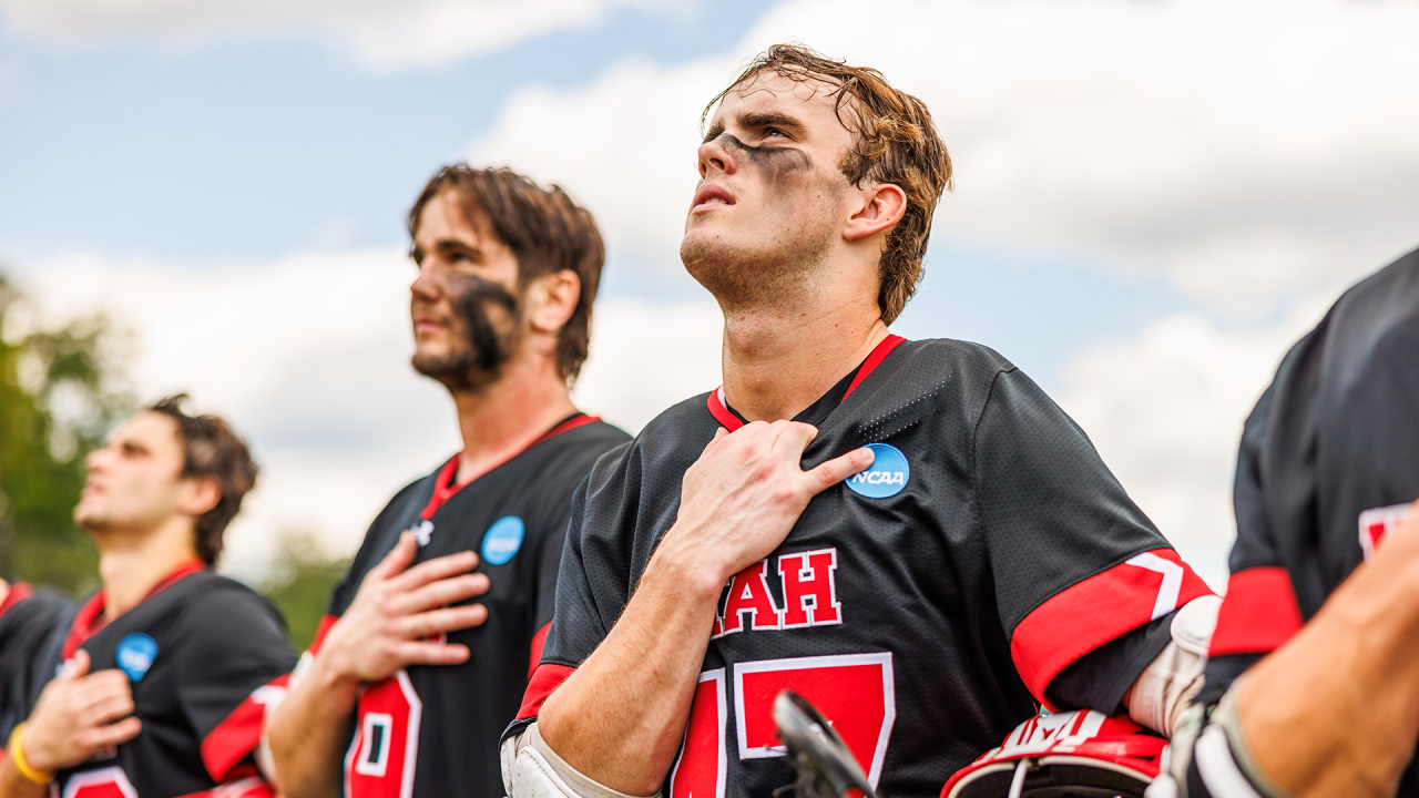 Utah lacrosse player Mikey Crane tugs at his jersey with the NCAA logo adjacent to his hand during the national anthem preceding the Utes' 2024 NCAA tournament game at Duke.