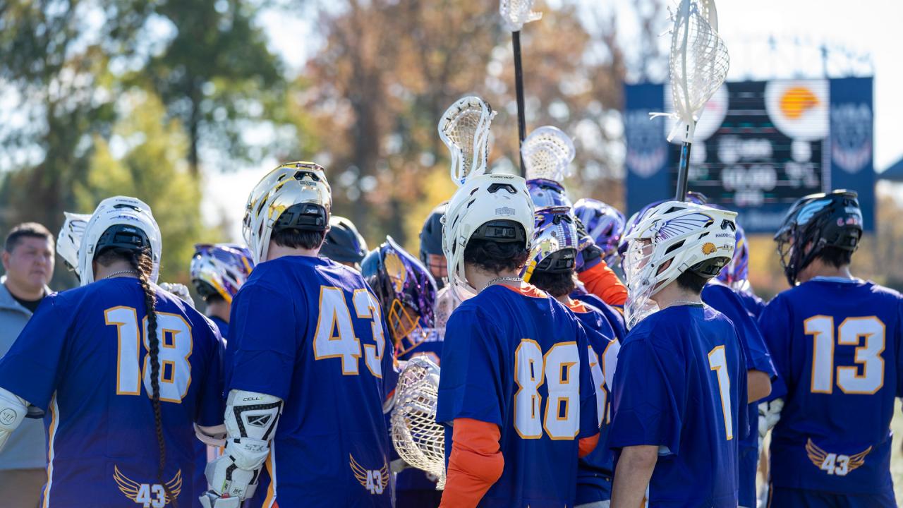 Haudenosaunee boys' lacrosse players in a huddle during the Brogden Cup
