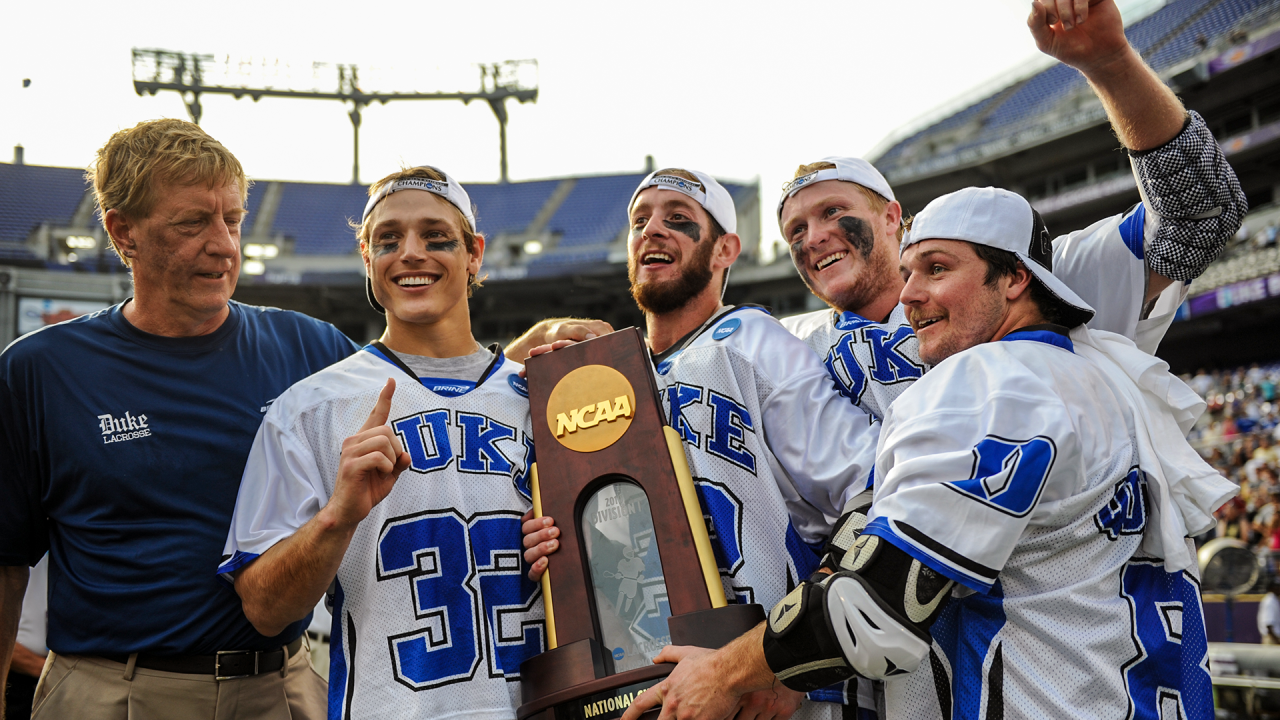 Surrounded by teammates and coach John Danowski, Ned Crotty poses with the 2010 NCAA championship trophy after Duke's 6-5 overtime triumph against Notre Dame at Baltimore's M&T Bank Stadium.
