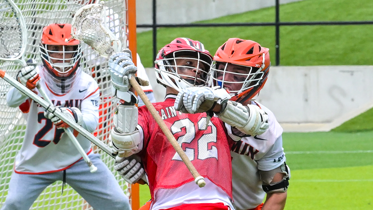 Saint Andrew's (Fla.) lacrosse player Dylan Faison backs into a Benjamin (Fla.) defender in matchup of Florida high school lacrosse powerhouses.