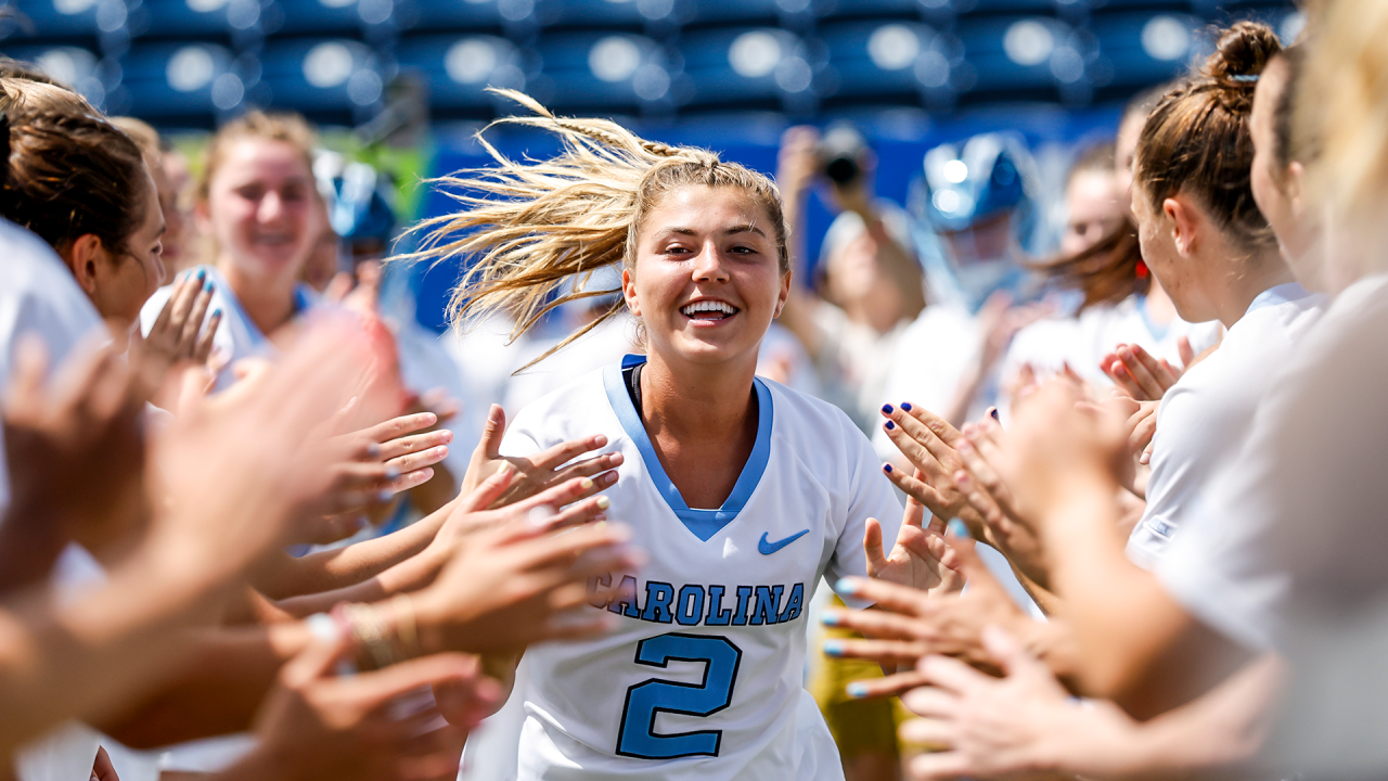 North Carolina women's lacrosse player Chloe Humphrey runs through a tunnel of high fives before the ACC semifinals against Boston College in Charlotte, N.C.