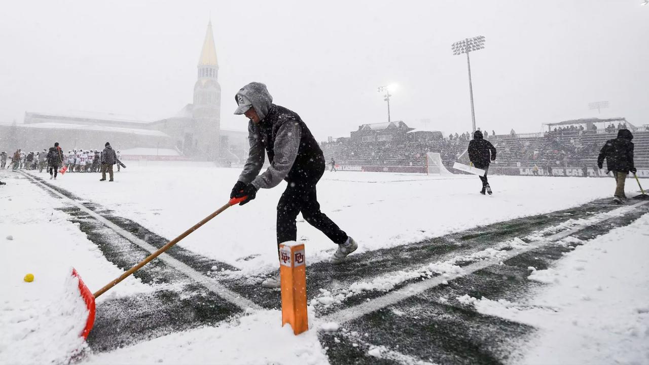 Denver staff shovel the lacrosse field