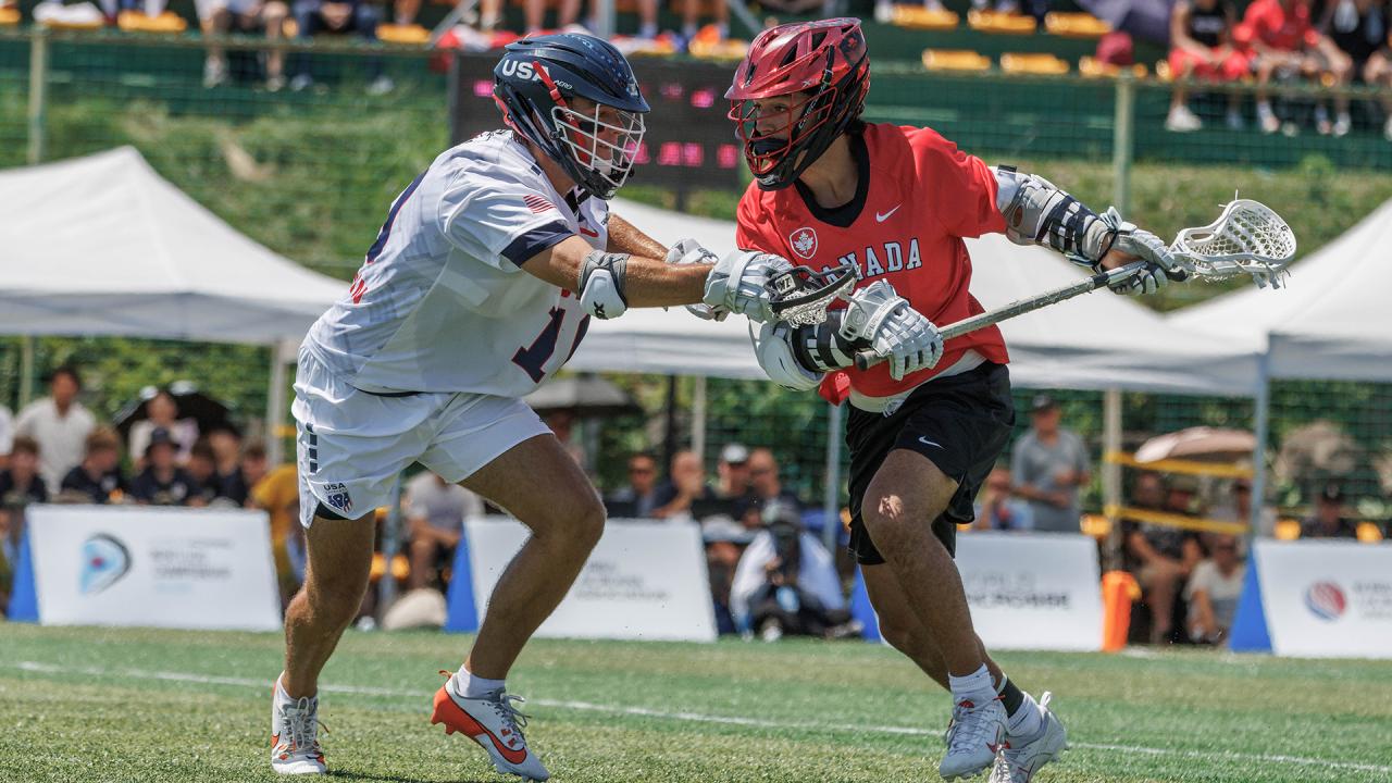 A USA defender guards a Canadian offensive player in the world championship game