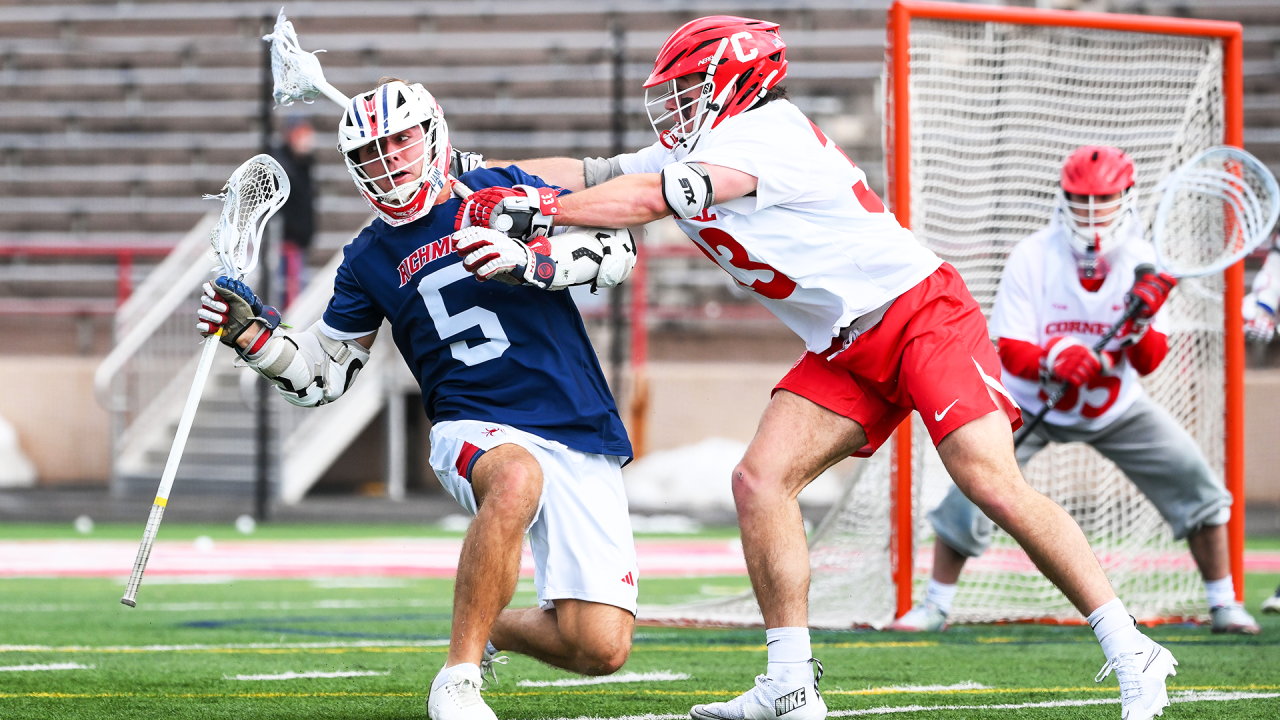 Richmond attackman Aidan O'Neil keeps his eye on the ball while under duress from Cornell defenseman Brendan Staub.