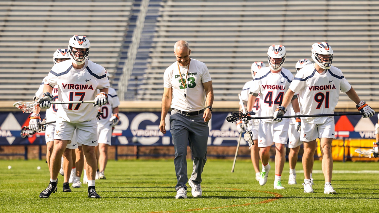 Virginia men's lacrosse coach Lars Tiffany with his team before a game against Utah at Scott Stadium in Charlottesville, Va.