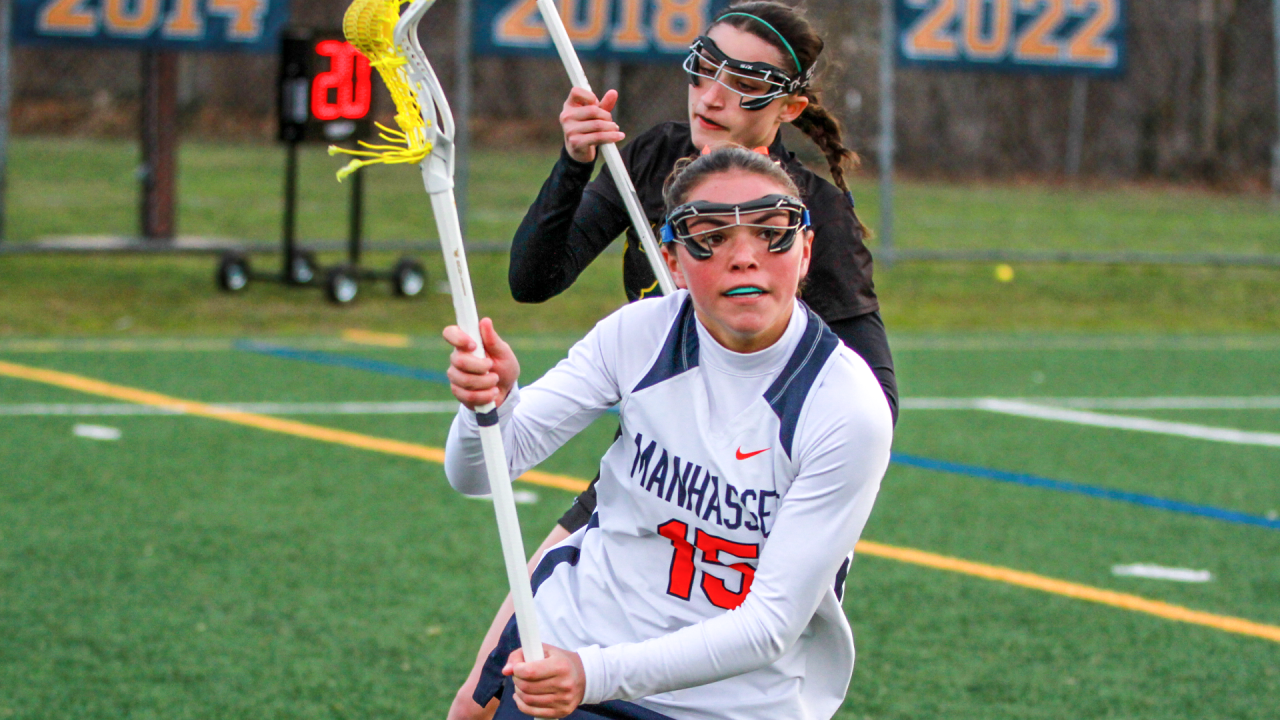 Manhasset girls' lacrosse player in action against Lynbrook