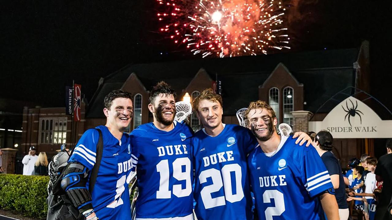 Duke players huddle as fireworks go off in the background