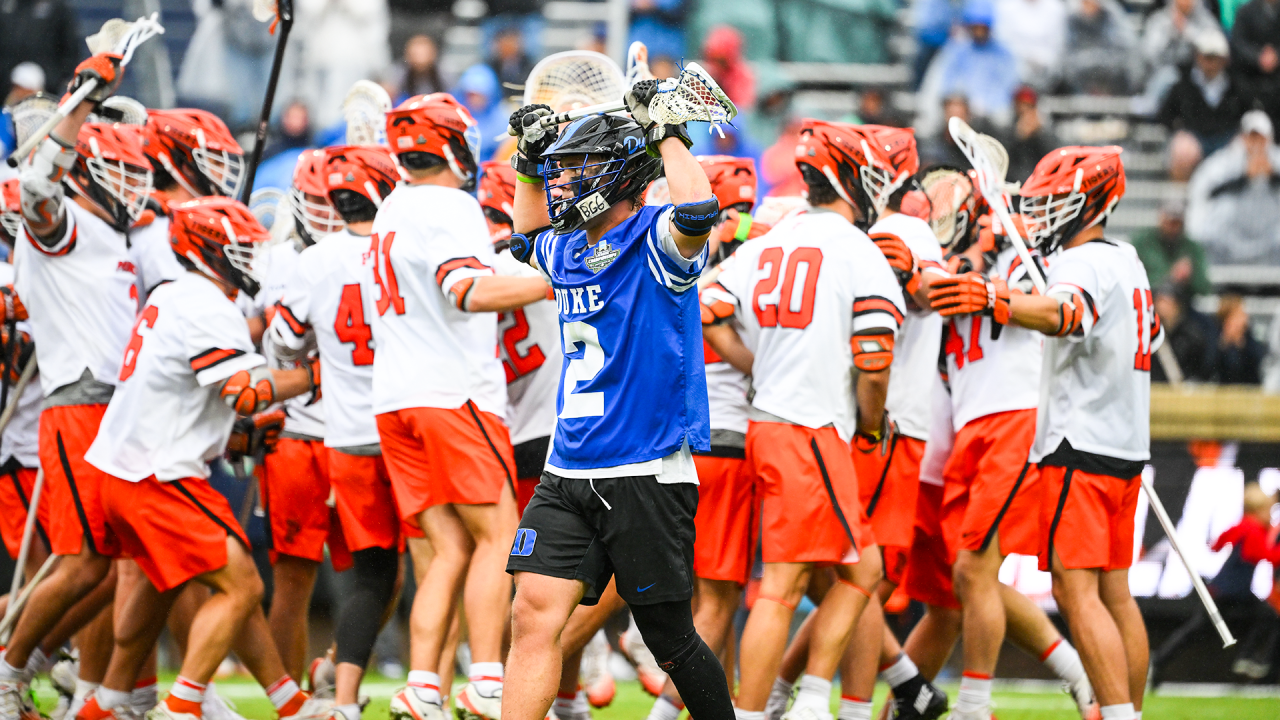 Duke lacrosse player Kyle Colsey hangs his stick on his helmet while Syracuse celebrates its NCAA semifinal victory at Scott Stadium in Charlottesville, Va.